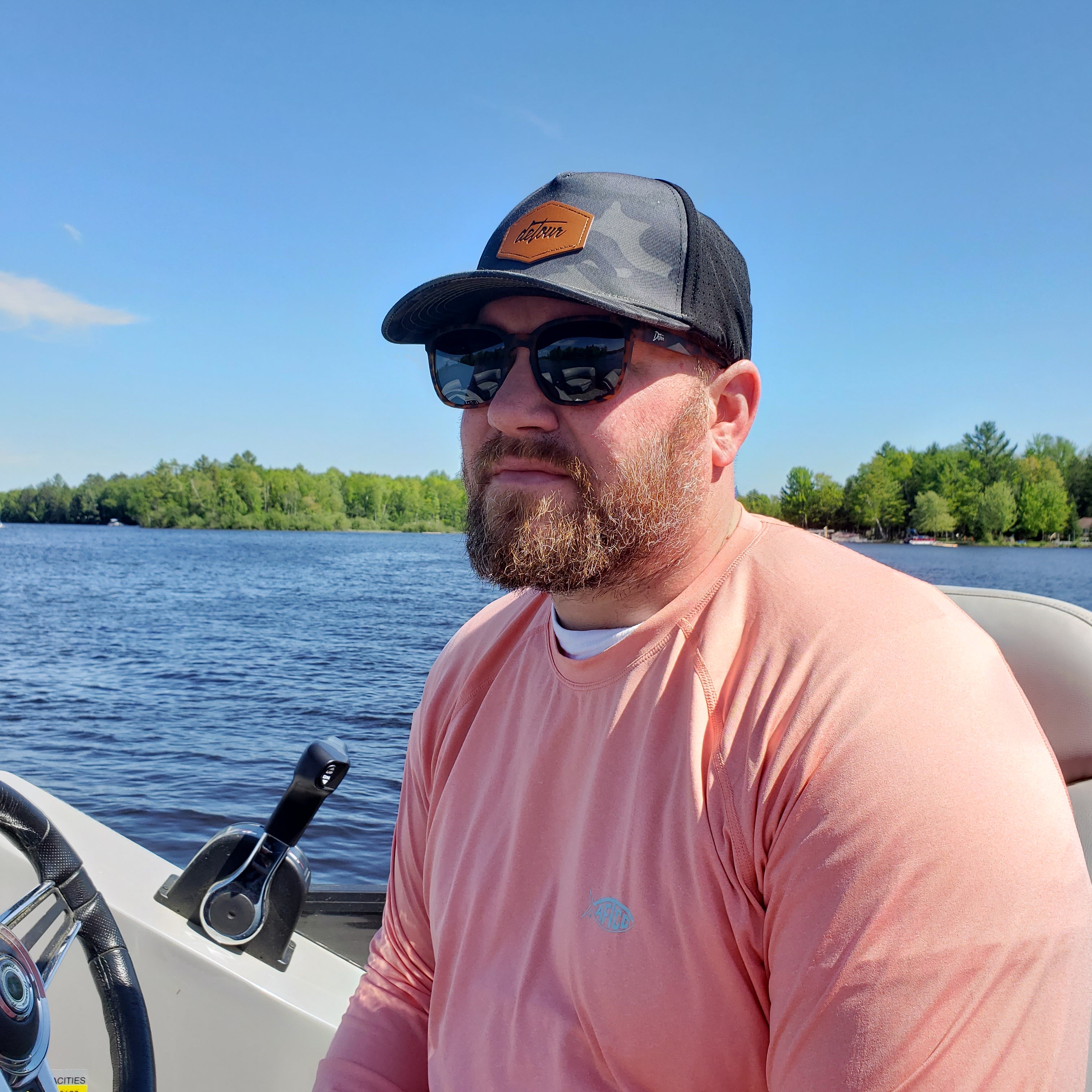 Man wearing mirrored goggles and gray beanie, holding skis in a snowy setting.
