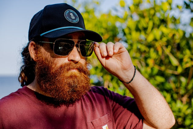 Snowboarder carving through powder in snowy terrain.